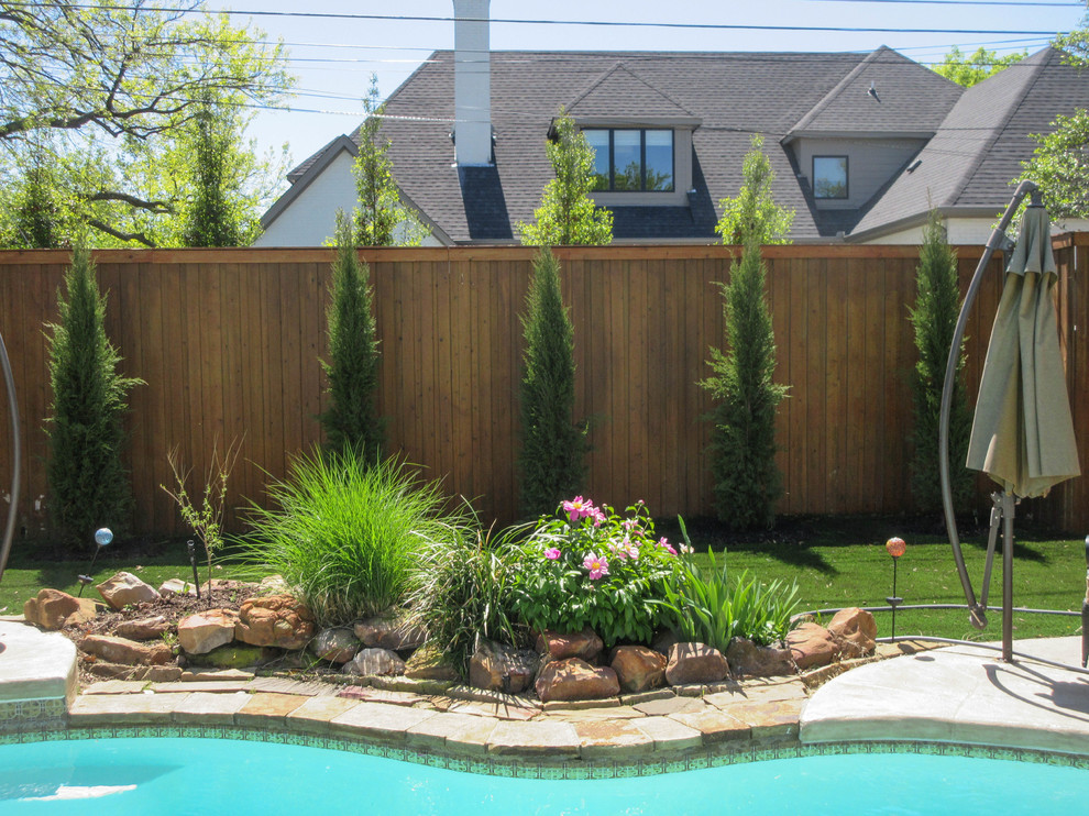 This is an example of a small traditional drought-tolerant and full sun backyard stone landscaping in Dallas.