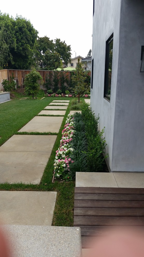 На фото: большой солнечный участок и сад на заднем дворе в стиле модернизм с хорошей освещенностью и мощением тротуарной плиткой с