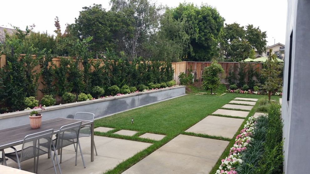 Esempio di un grande giardino moderno esposto in pieno sole dietro casa con pavimentazioni in cemento
