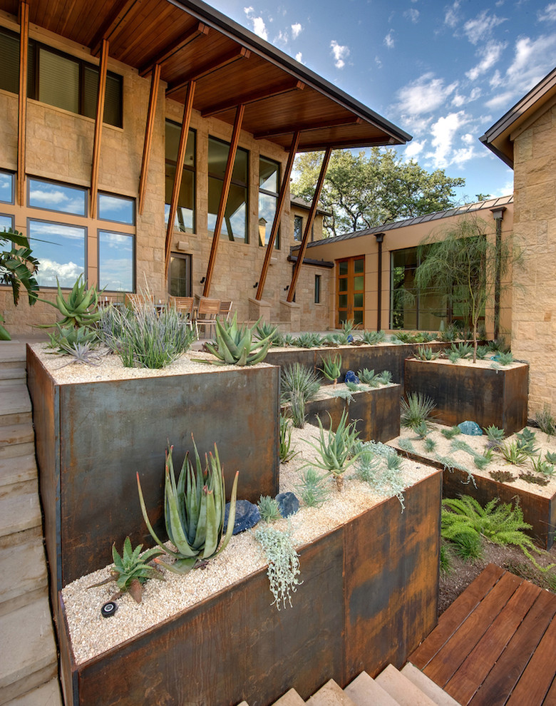 Источник вдохновения для домашнего уюта: солнечный засухоустойчивый сад на склоне в стиле фьюжн с хорошей освещенностью и мощением тротуарной плиткой
