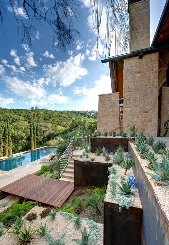 Foto di un grande giardino xeriscape minimalista esposto in pieno sole con un muro di contenimento, un pendio, una collina o una riva e pavimentazioni in cemento