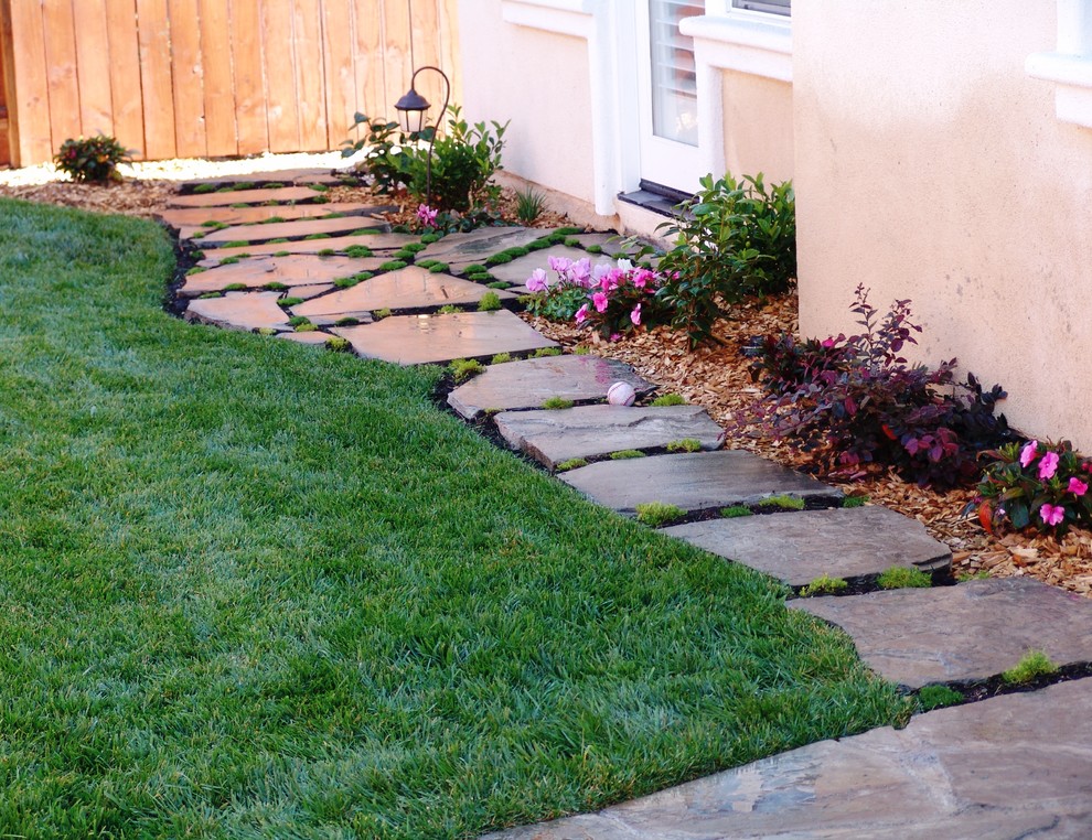 This is an example of a mid-sized transitional full sun backyard stone landscaping in San Luis Obispo.