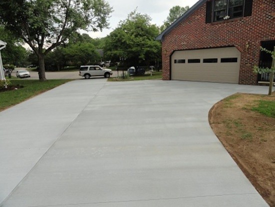 This is an example of a classic front driveway garden in Other with concrete paving.
