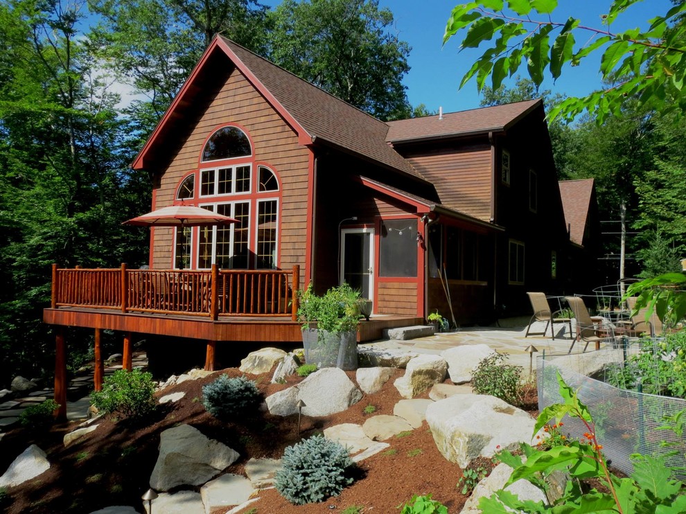 Medium sized back full sun garden in Portland Maine with a garden path and natural stone paving.