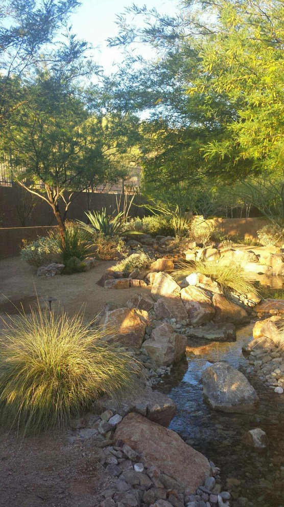 Ejemplo de jardín clásico de tamaño medio en patio trasero con estanque, exposición parcial al sol y adoquines de piedra natural