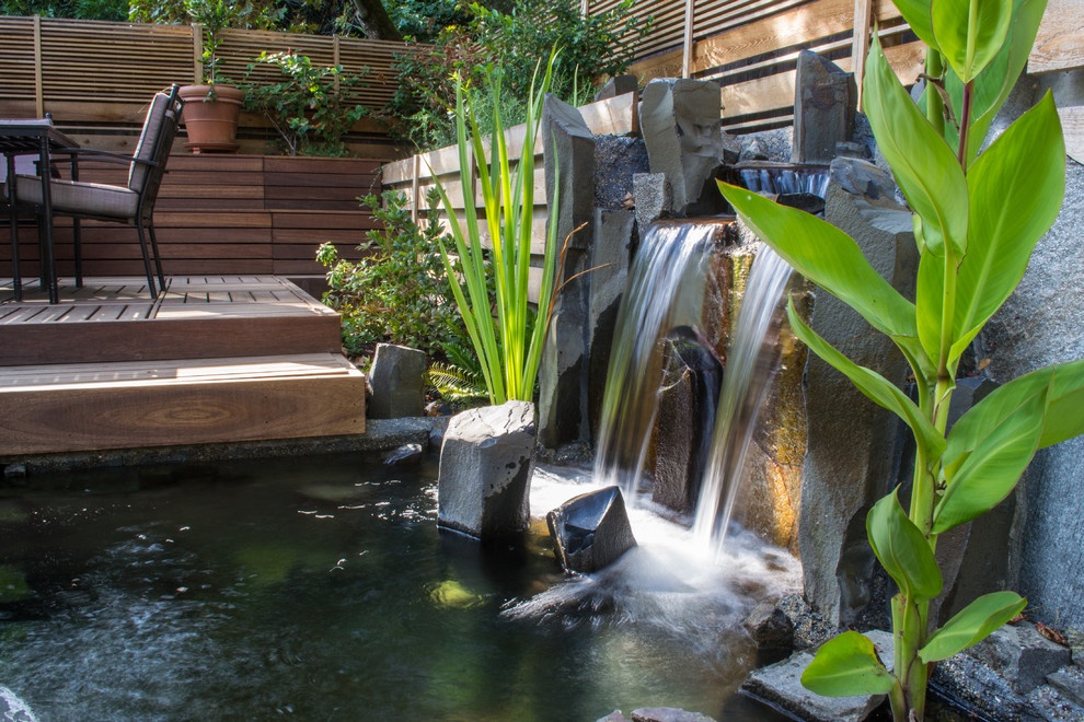 This is an example of a small asian backyard water fountain landscape in Portland.
