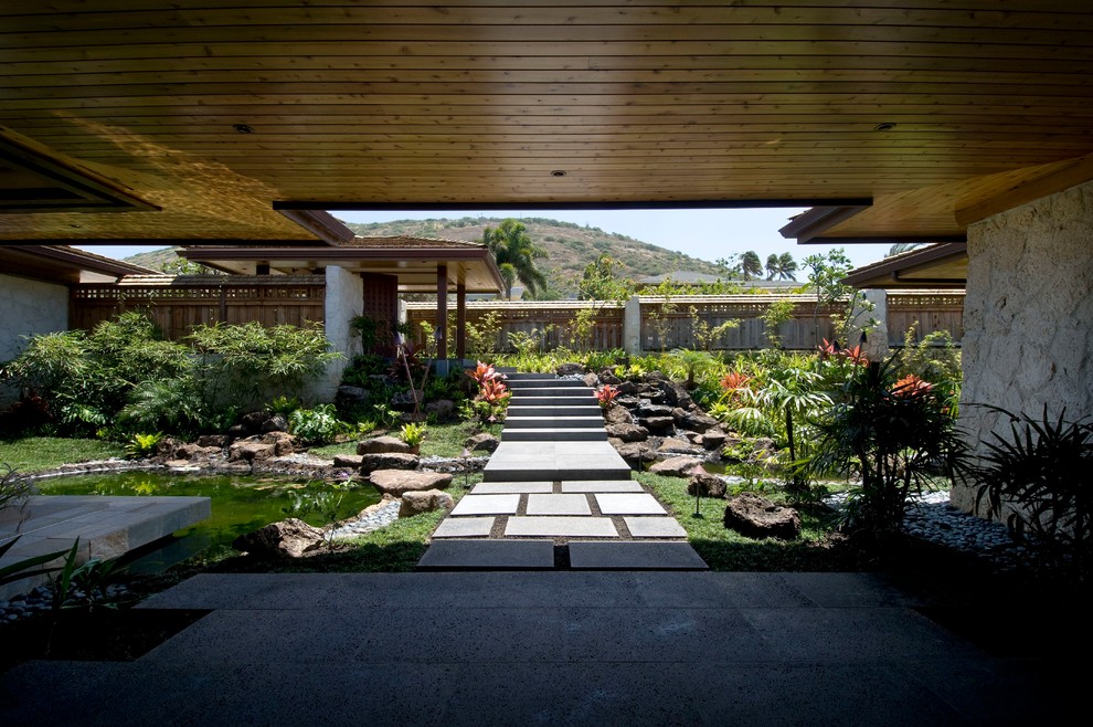 Exempel på en stor exotisk bakgård i delvis sol, med en trädgårdsgång och marksten i betong
