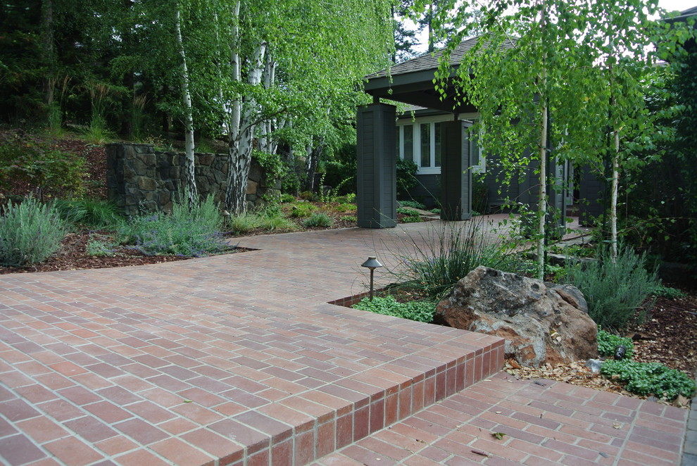 Cette image montre un jardin avant traditionnel avec des pavés en brique.