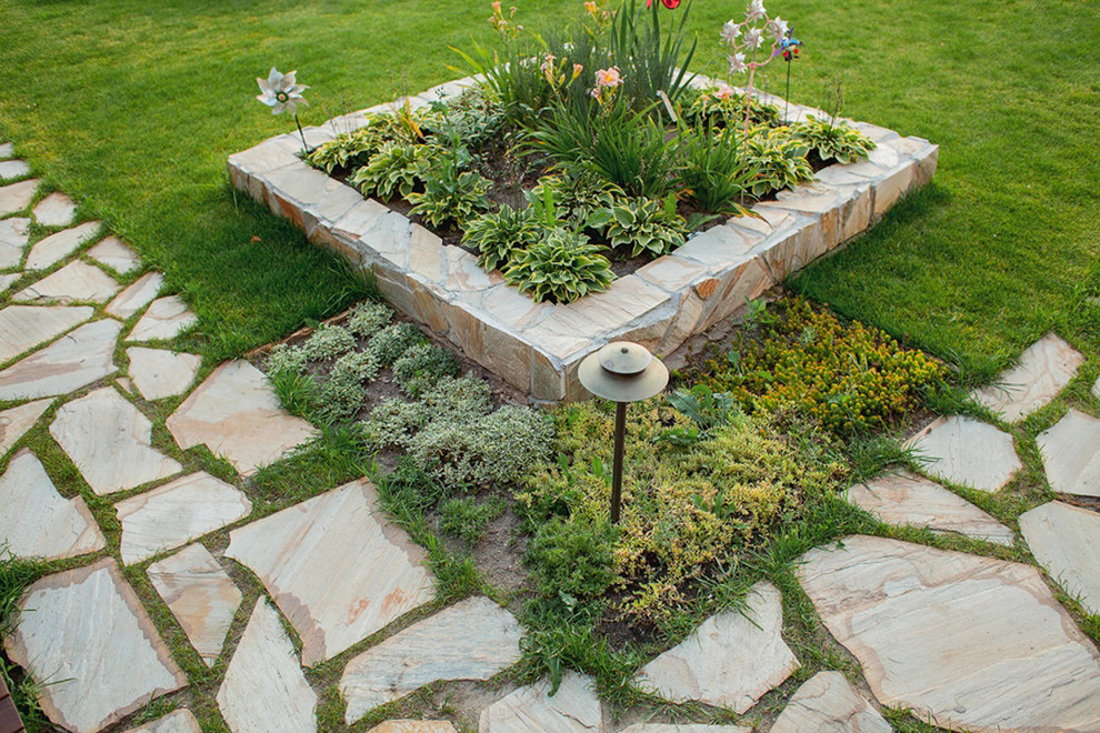 Contemporary full sun garden in Moscow with natural stone paving.