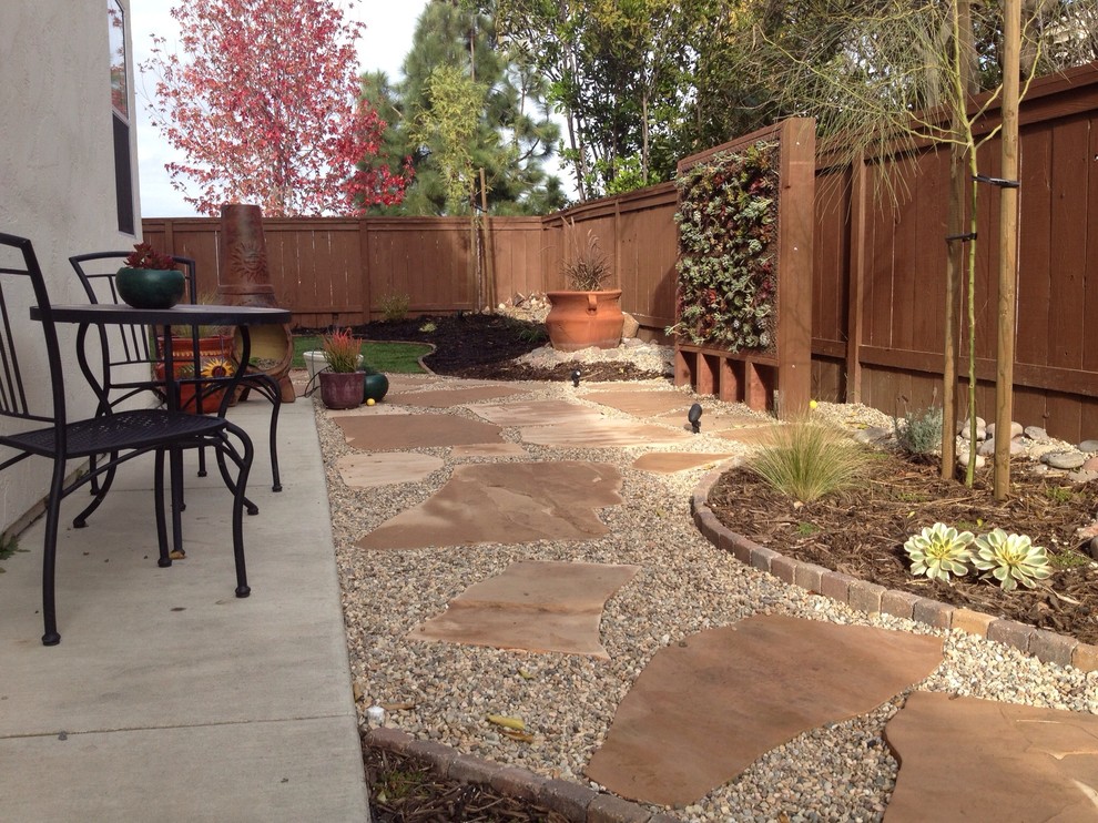 Photo of a large rustic side partial sun garden for winter in San Diego with a living wall and natural stone paving.