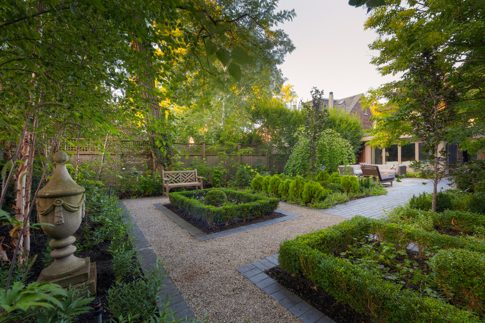 Diseño de camino de jardín tradicional en patio trasero con jardín francés y gravilla