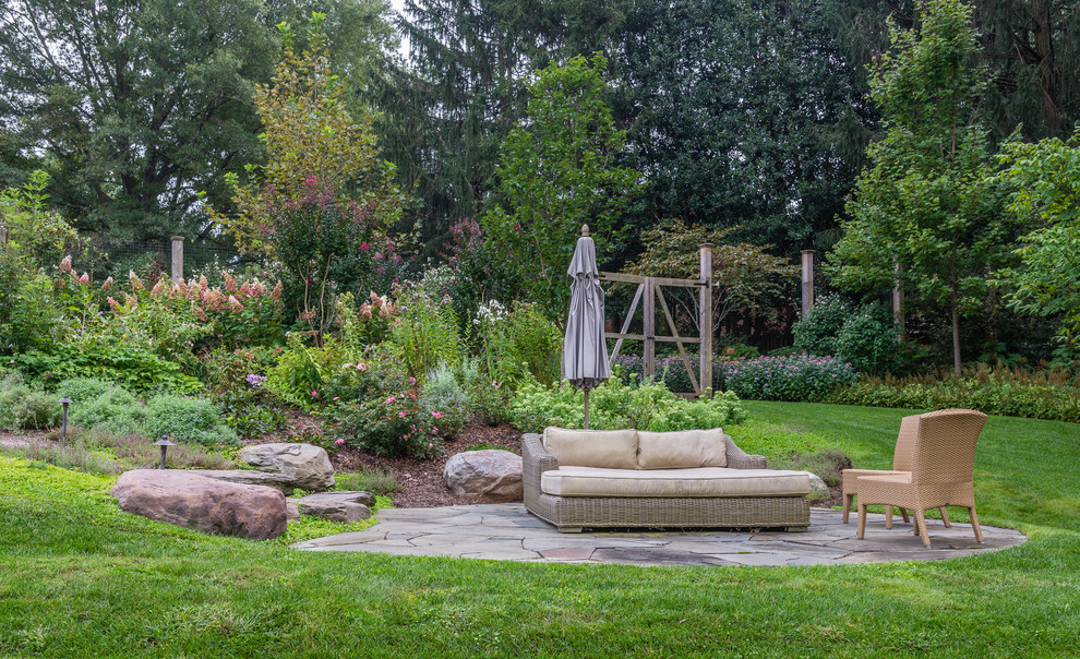 Foto di un grande giardino formale country esposto in pieno sole in estate con pavimentazioni in pietra naturale e un pendio, una collina o una riva