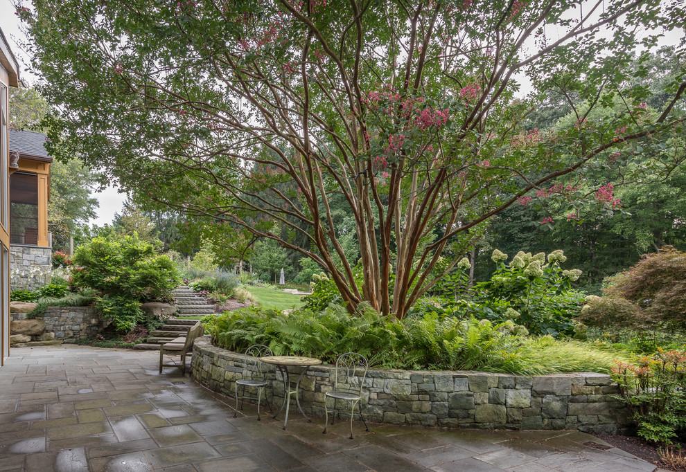 Immagine di un grande giardino formale country esposto a mezz'ombra nel cortile laterale in estate con pavimentazioni in pietra naturale