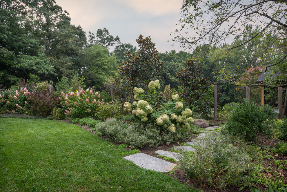 Idée de décoration pour un grand jardin latéral champêtre l'été avec une exposition partiellement ombragée et des pavés en pierre naturelle.