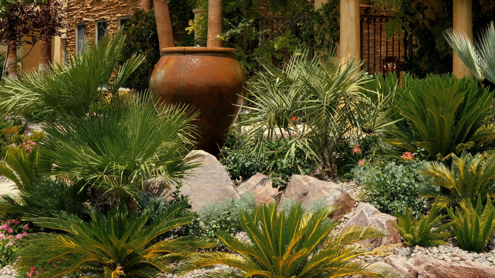 Esempio di un grande giardino xeriscape mediterraneo esposto a mezz'ombra davanti casa con pavimentazioni in pietra naturale