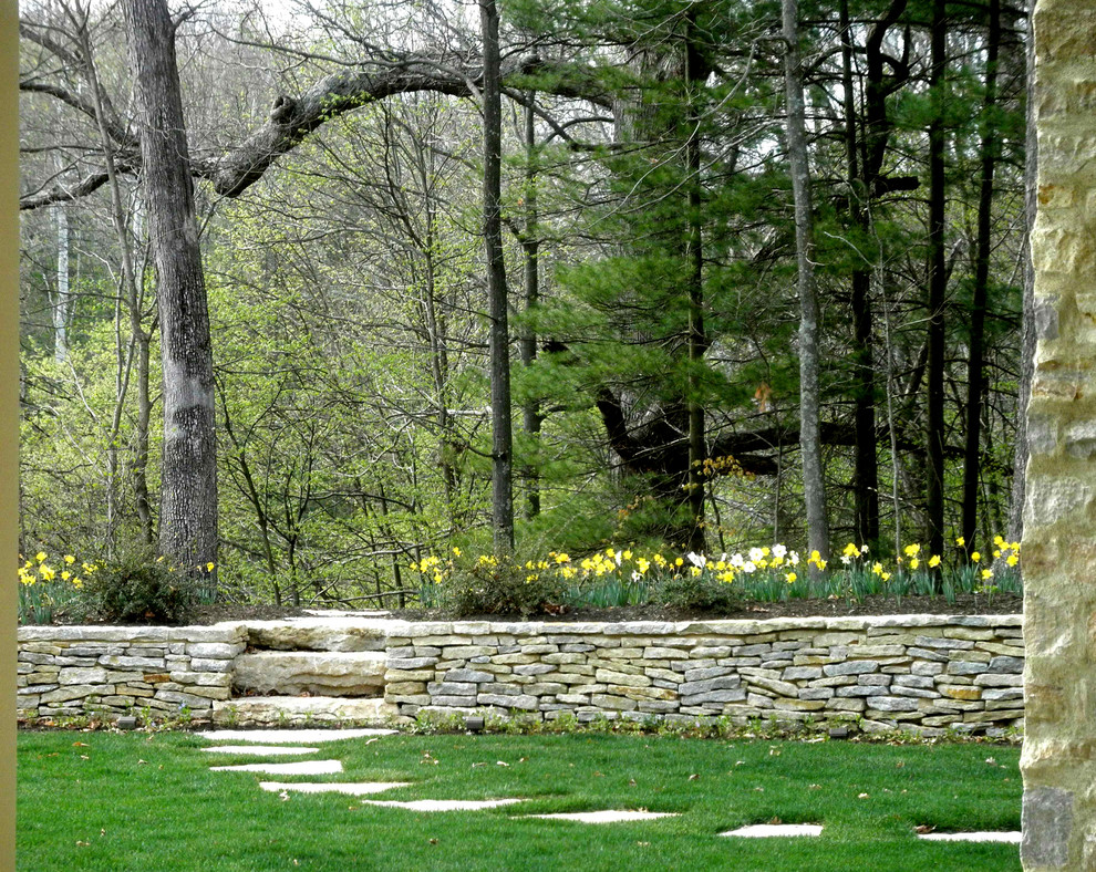 Immagine di un giardino classico dietro casa con pavimentazioni in pietra naturale e scale