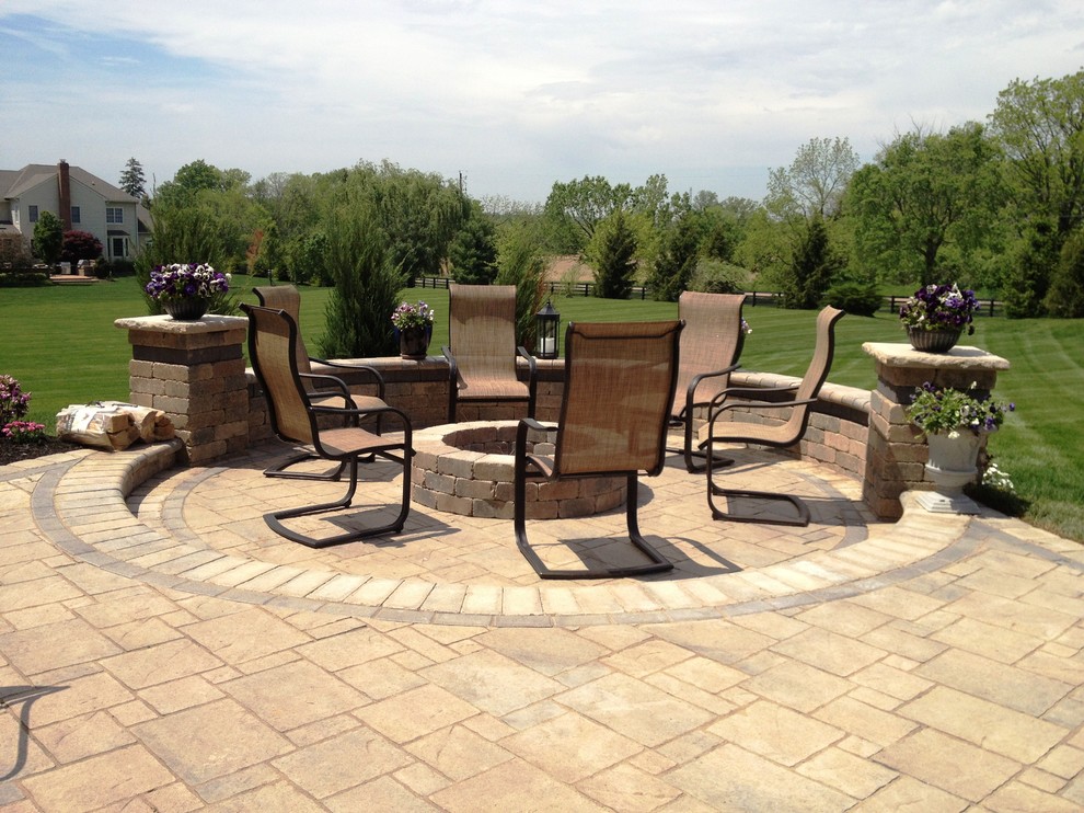This is an example of a large classic back patio in Columbus with a fire feature and brick paving.