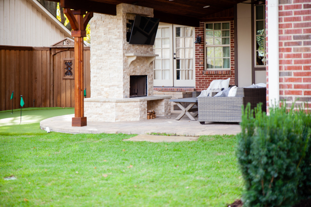 Halbschattiger Klassischer Gartenkamin hinter dem Haus mit Natursteinplatten und Holzzaun in Dallas