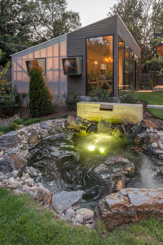 На фото: большой садовый фонтан на заднем дворе в современном стиле с полуденной тенью с