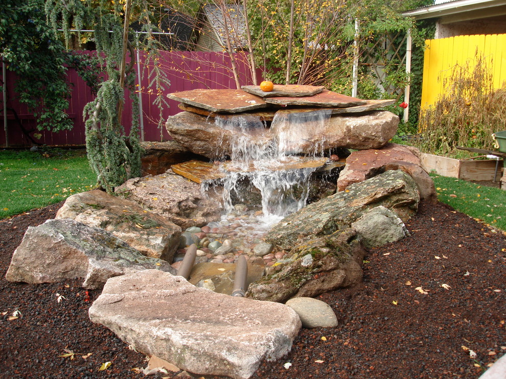 На фото: маленький весенний садовый фонтан на заднем дворе в классическом стиле с покрытием из каменной брусчатки и полуденной тенью для на участке и в саду
