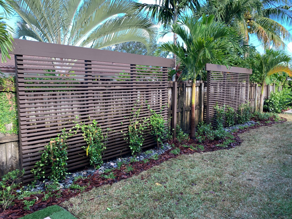 Large contemporary back private full sun garden for summer in Miami.