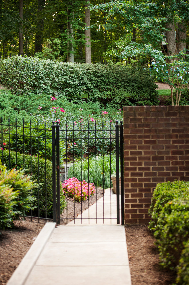 This is an example of a large traditional front driveway garden in DC Metro with a garden path.
