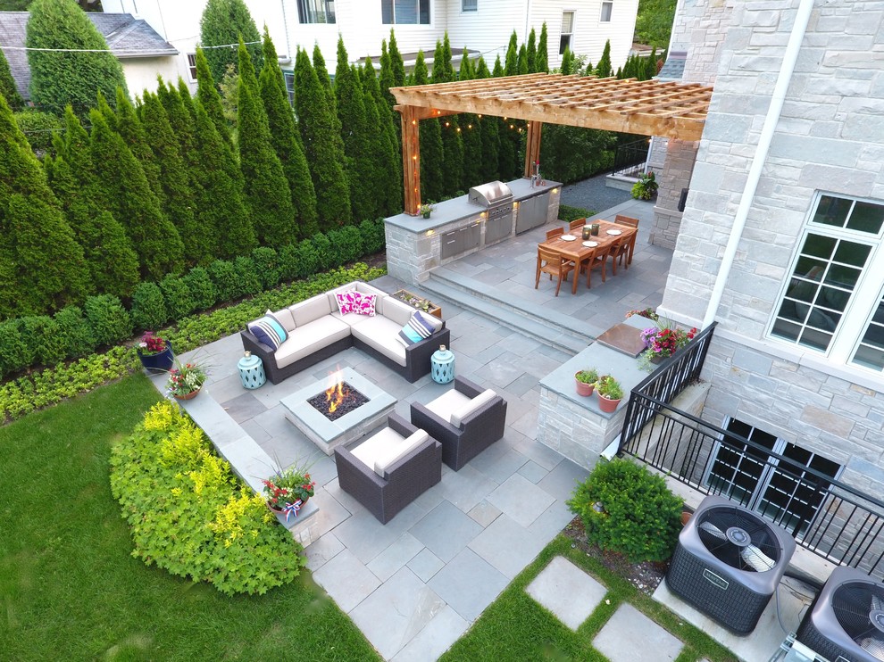 Пример оригинального дизайна: большой двор на заднем дворе в современном стиле с местом для костра и покрытием из каменной брусчатки