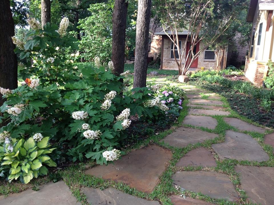 Inspiration for a large transitional shade backyard stone landscaping in Dallas.