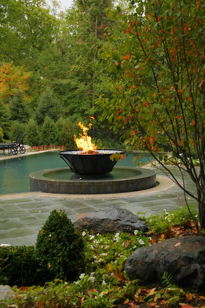 Inspiration for a large traditional full sun backyard stone landscaping in Detroit with a fire pit.
