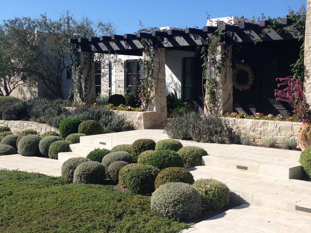 На фото: большой участок и сад в средиземноморском стиле с покрытием из каменной брусчатки