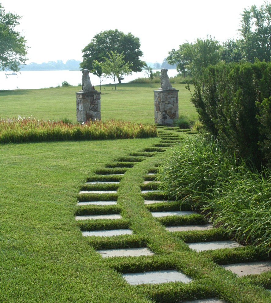 Aménagement d'un aménagement d'entrée ou allée de jardin arrière classique l'été avec une exposition ensoleillée et des pavés en pierre naturelle.