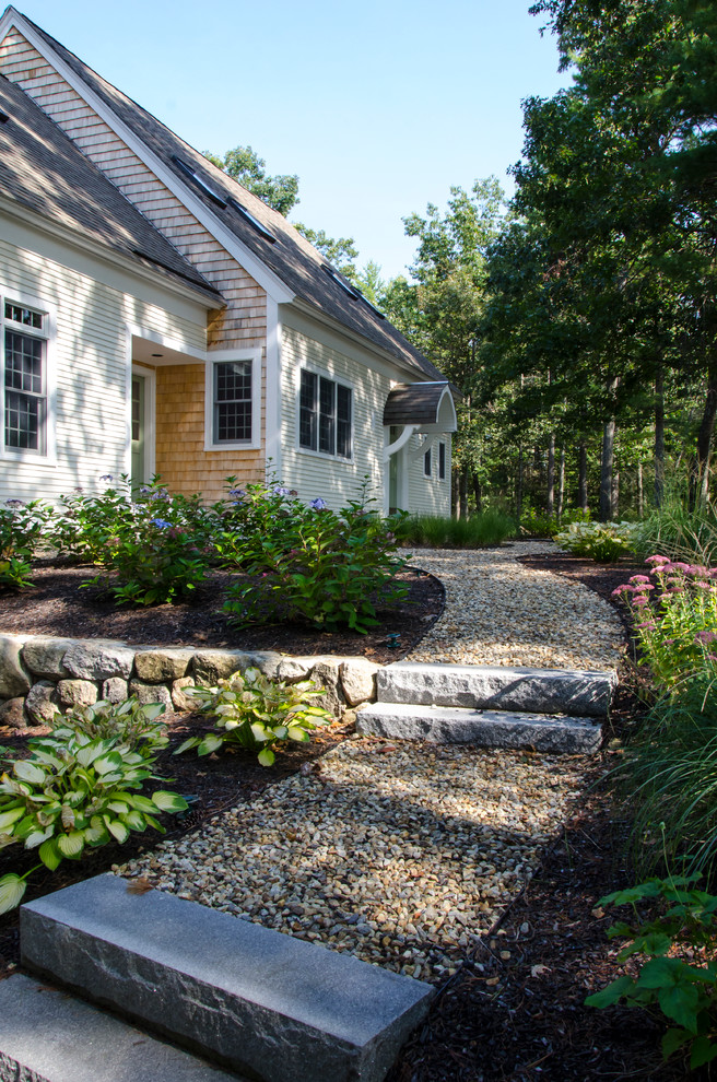 Medium sized classic front partial sun garden in Boston with gravel and a retaining wall.