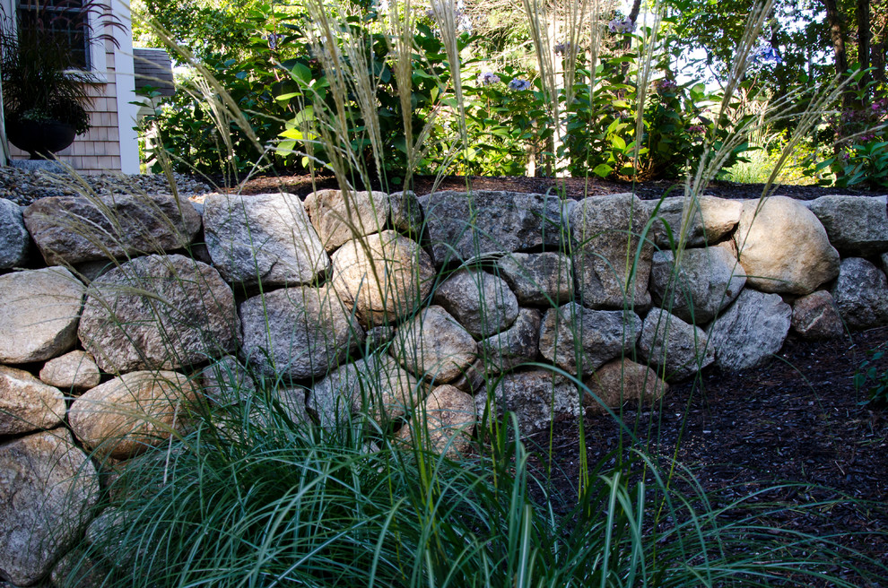 Réalisation d'un jardin avant tradition de taille moyenne avec un mur de soutènement, une exposition partiellement ombragée et du gravier.