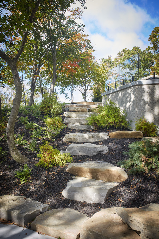Immagine di un grande giardino design esposto a mezz'ombra nel cortile laterale con pavimentazioni in pietra naturale