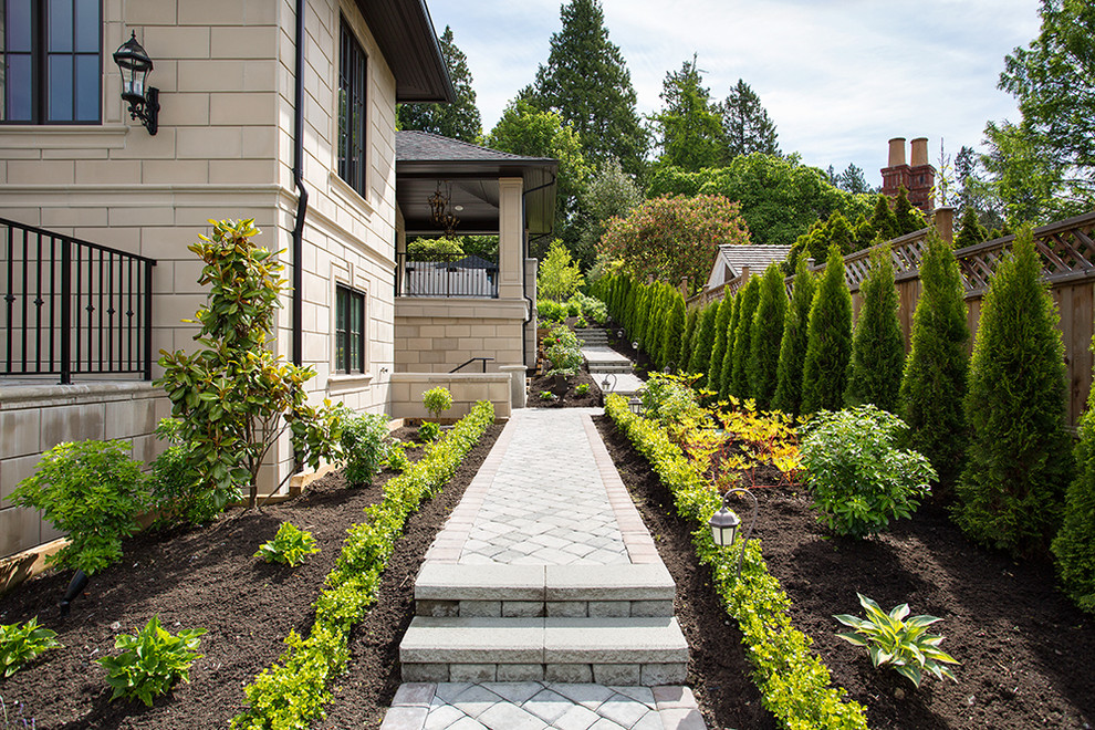 Idee per un grande giardino formale classico esposto a mezz'ombra nel cortile laterale con pavimentazioni in mattoni