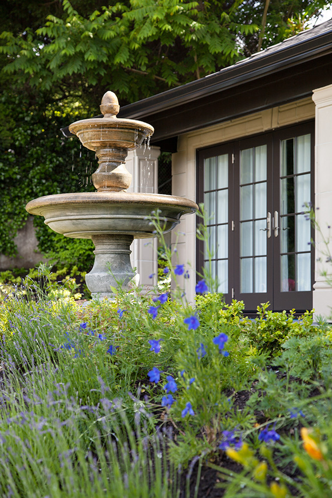 Imagen de jardín clásico grande con jardín francés, exposición parcial al sol y adoquines de ladrillo