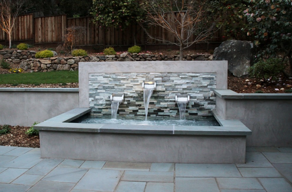 Idee per un grande patio o portico minimal dietro casa con fontane e pavimentazioni in pietra naturale