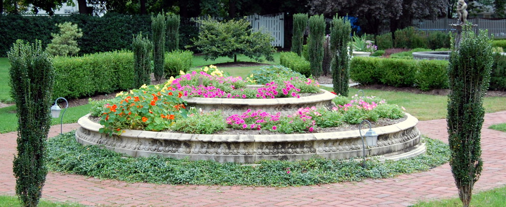 Diseño de jardín clásico grande en patio trasero con jardín francés, jardín de macetas, exposición total al sol y adoquines de ladrillo