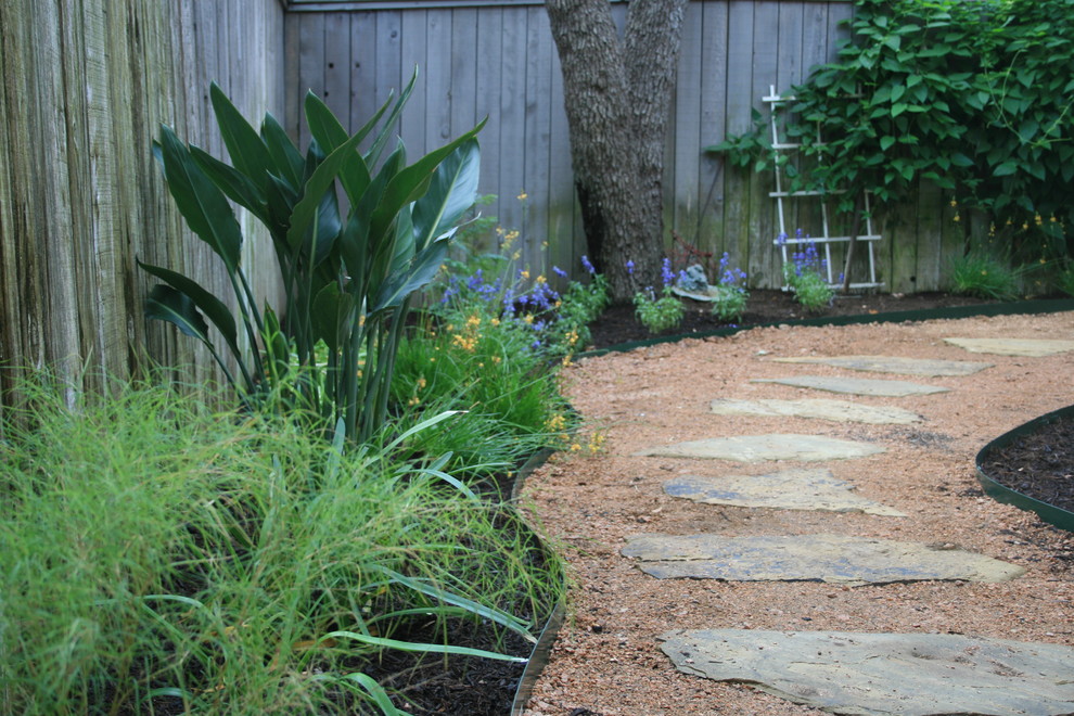 Foto di un giardino xeriscape minimalista esposto a mezz'ombra di medie dimensioni e dietro casa in estate con un ingresso o sentiero e ghiaia