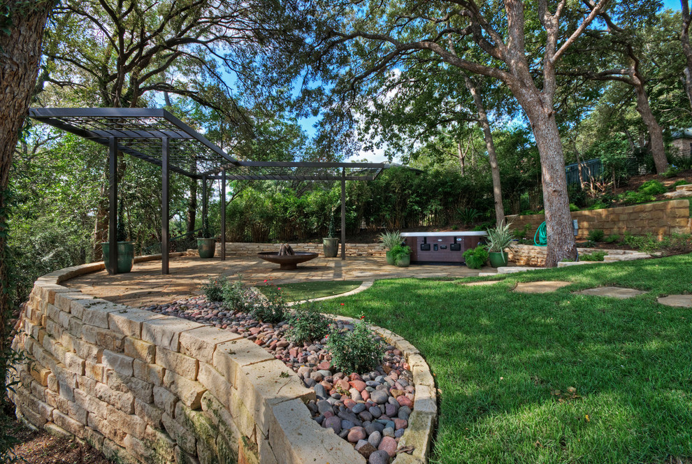 Immagine di un grande giardino formale classico esposto a mezz'ombra davanti casa in primavera con un muro di contenimento e pavimentazioni in pietra naturale