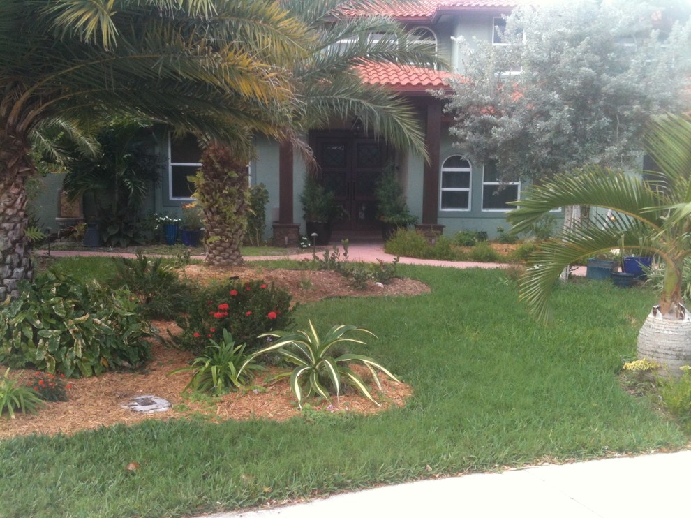 This is an example of a large tropical front yard landscaping in Miami.