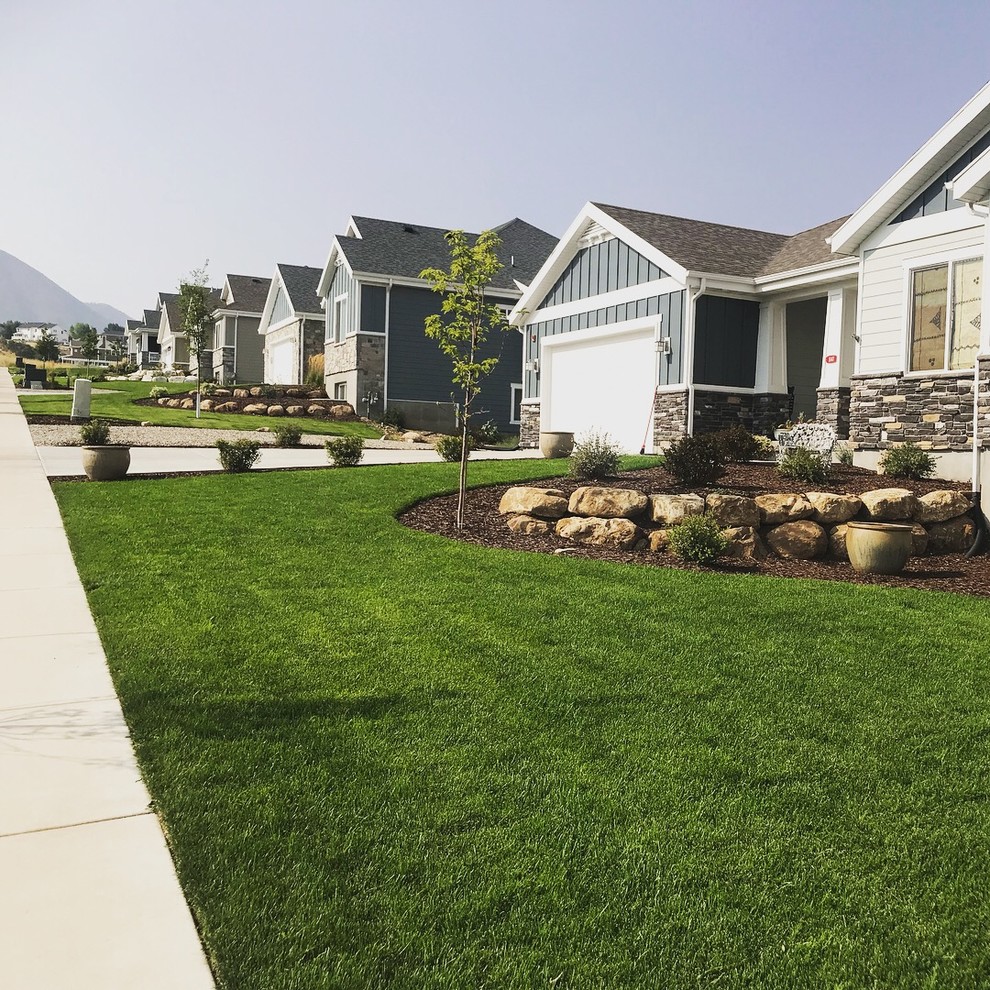 This is an example of a mid-sized traditional rock and full sun front yard mulch landscaping in Salt Lake City.
