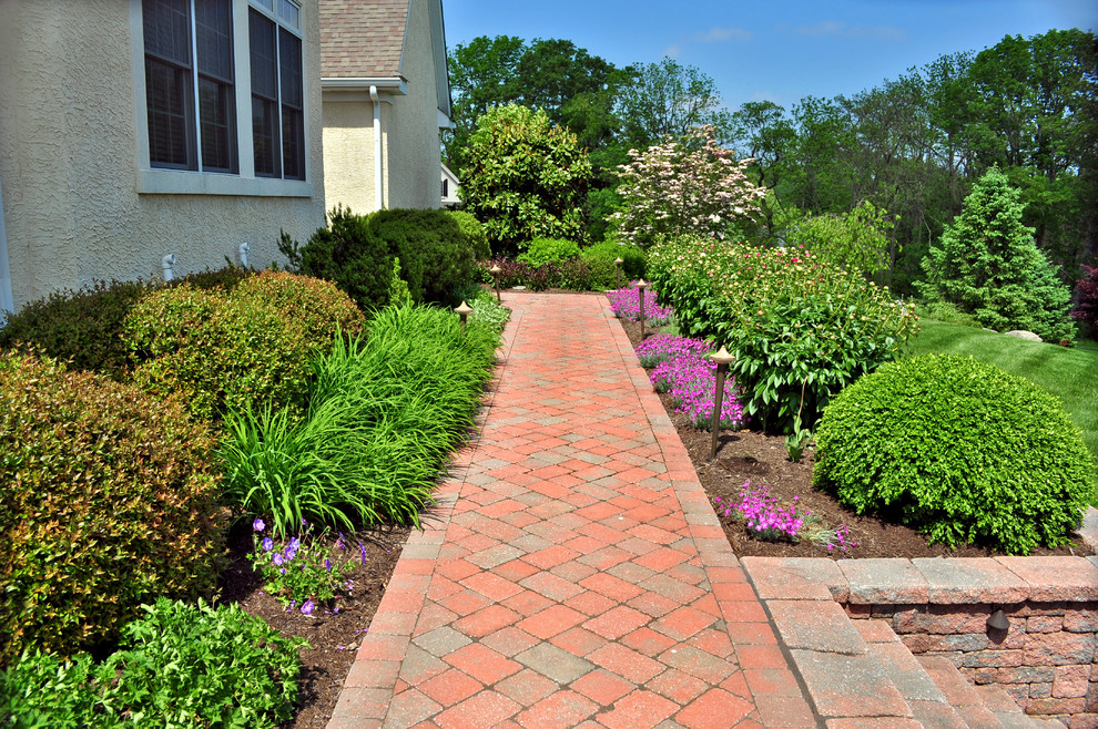 Photo of a large traditional front driveway full sun garden in Philadelphia with a garden path and natural stone paving.