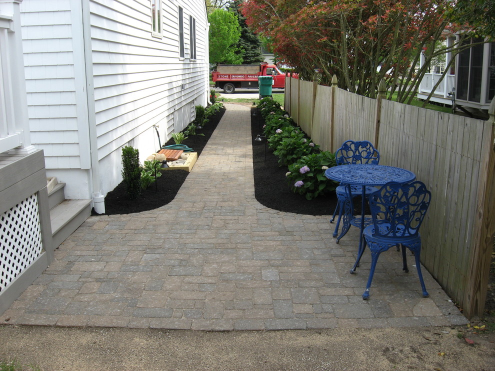 This is an example of a medium sized classic side formal partial sun garden in Philadelphia with a garden path and brick paving.