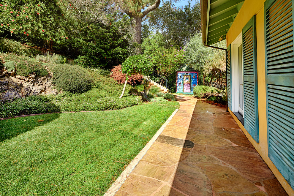 На фото: большой солнечный регулярный сад на заднем дворе в средиземноморском стиле с хорошей освещенностью и покрытием из каменной брусчатки с