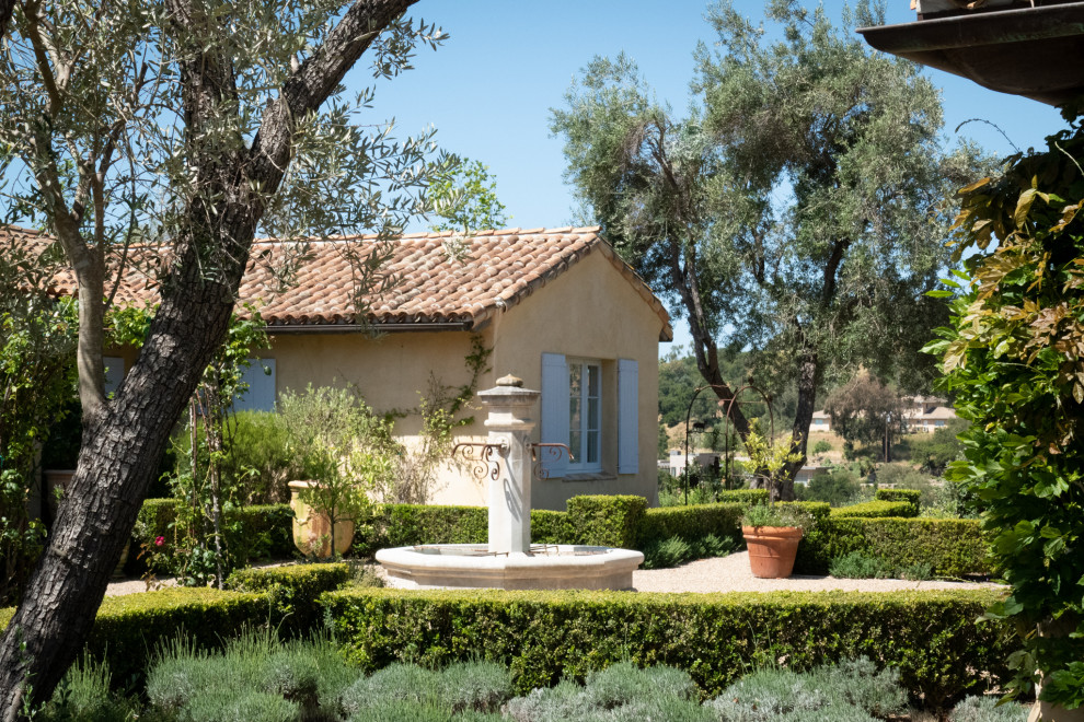Photo of a large mediterranean front xeriscape full sun garden in Santa Barbara with a water feature and gravel.