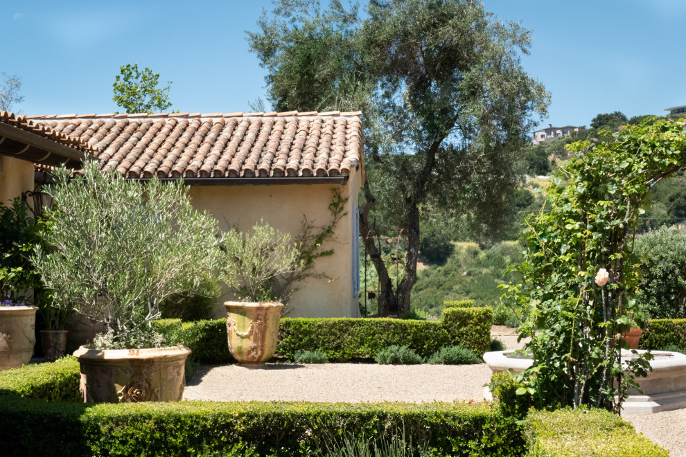 На фото: большой солнечный, осенний участок и сад на внутреннем дворе в средиземноморском стиле с хорошей освещенностью и покрытием из гравия
