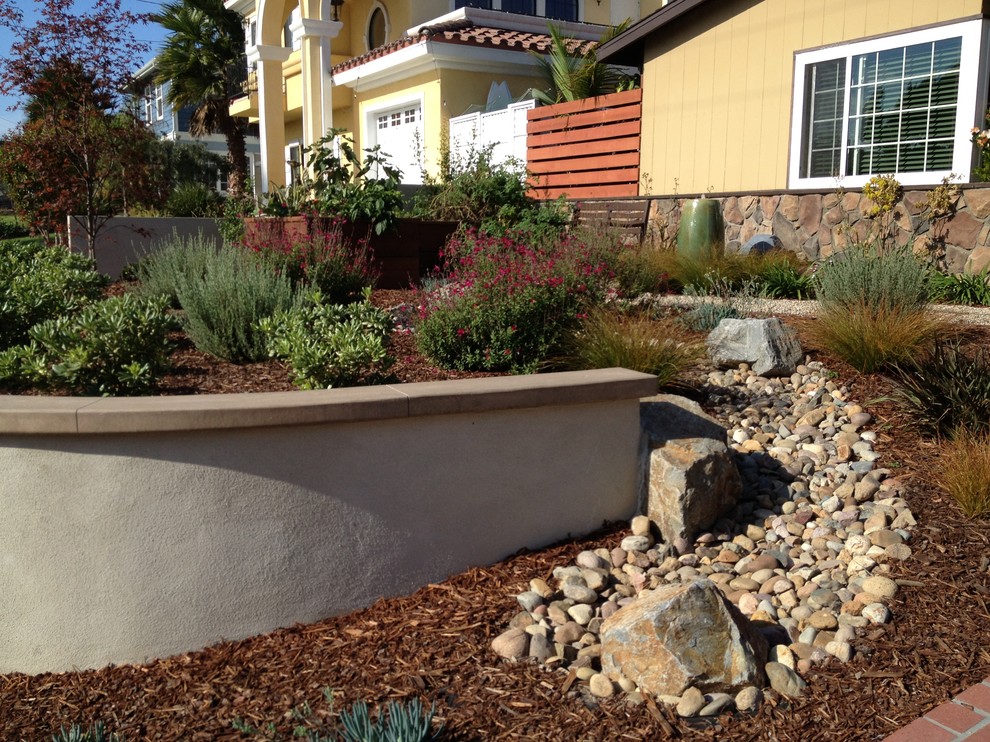 Photo of a small mediterranean drought-tolerant and full sun front yard stone landscaping in San Diego.