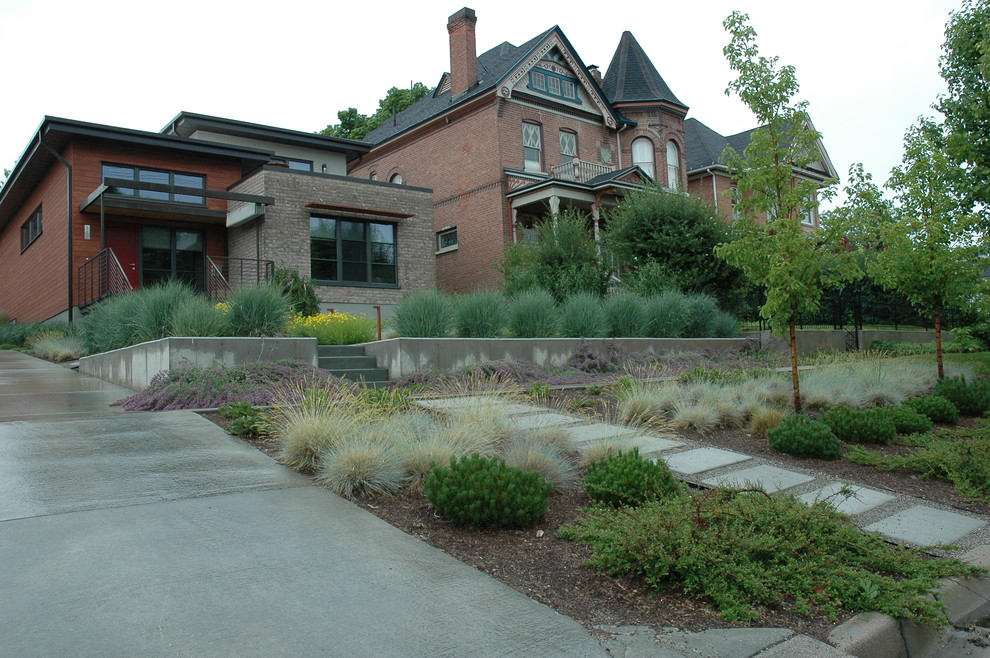 Immagine di un giardino xeriscape moderno esposto in pieno sole di medie dimensioni e davanti casa in estate con un ingresso o sentiero e pavimentazioni in cemento