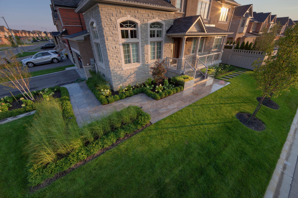 Photo of a mid-sized contemporary full sun front yard stone landscaping in Toronto for summer.